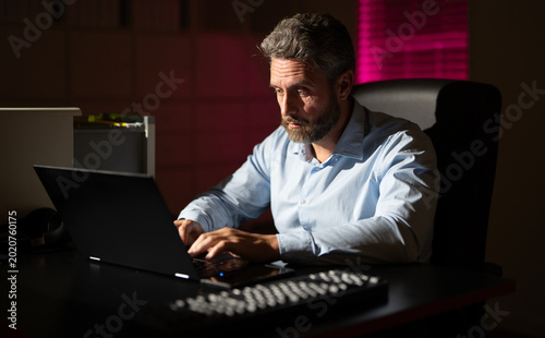 Картината върху платно Businessman concentrating on career tasks late in the night