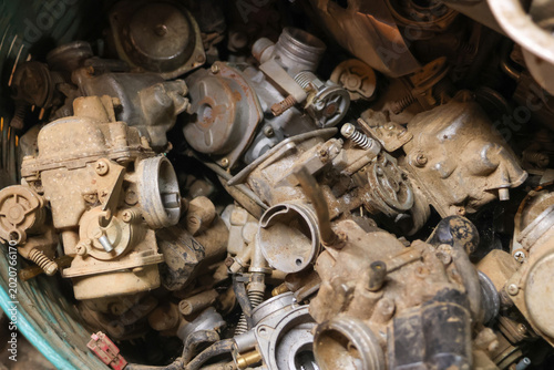 Schilderij op canvas Pile of old rusty metal carburetor engine part scrap junk dirty and neglected feeling forgotten workshop