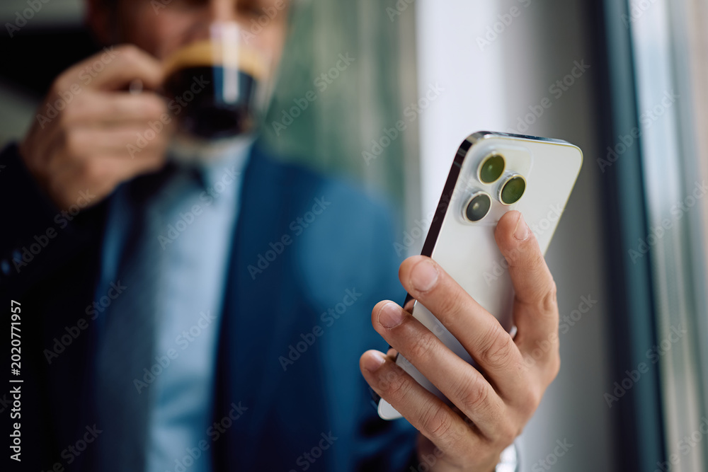 Fototapeta premium Close up of businessman using smart phone in office.