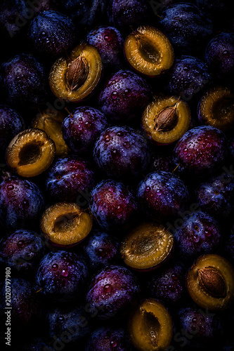 Dark Moody Plums with Water Droplets on Black Background