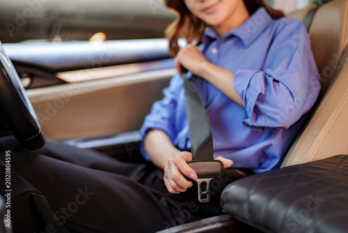 Woman buckling seatbelt ensuring safety before driving journey
