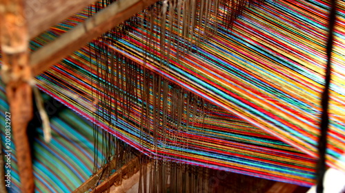 Close up view of Craftsmanship in Progress Bright Multicolored Threads on a Traditional Weaving Loom. vibrant array of multicolored threads.