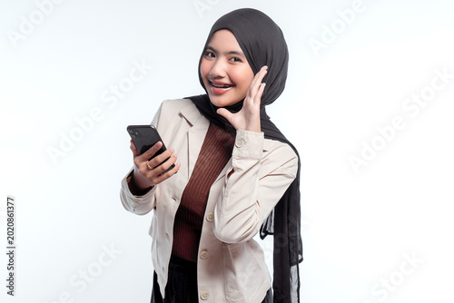 Young woman smiles while holding smartphone