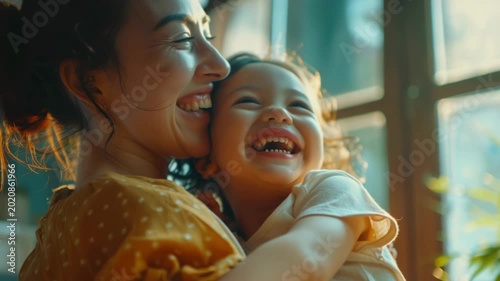 Joyful moment between a woman and young child in warm sunlight.