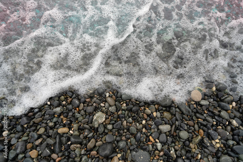Schilderij op canvas foamy sea wave on pebble