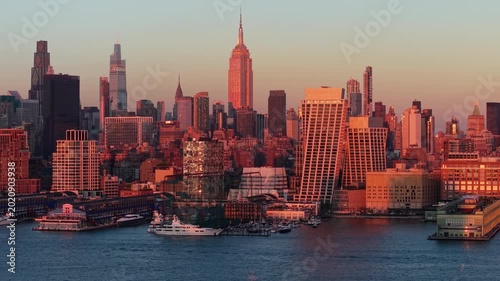 Aerial panning view of Manhattan skyscrapers and Chelsea waterfront at sunset. Midtown West in New York City along the Hudson River