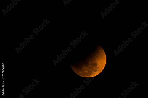 Photos Partial Lunar Eclipse with Shadowed Moon Detail Against Night Sky