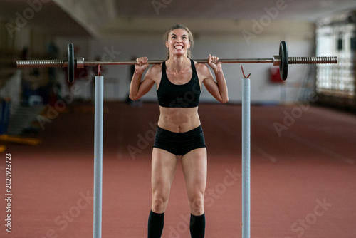 Cuadro en lienzo Female athlete make an effort barbell squat jump exercise