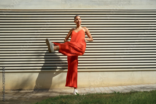 Obraz na płótnie Lively female athlete in bright attire executes vigorous kick with vibrant motio