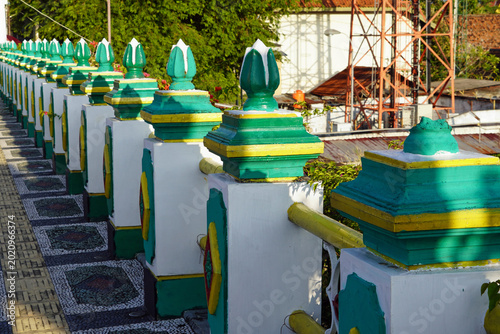 Obraz na plátně Colorful decorative bridge railing overlooking a humble riverside residential ne