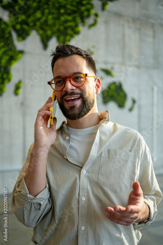 Smiling man talking on phone with world map behind