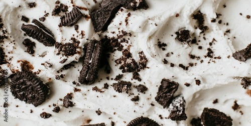 Cookies and cream ice cream texture with chocolate cookie crumbs for dessert branding and food background design.