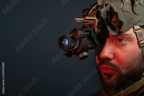 Professional night vision device on tactical operator with copy space and high tech image intensifier components