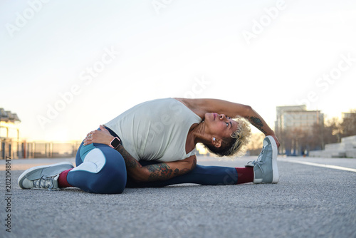 Obraz na płótnie Latina woman stretching outdoors doing yoga exercise