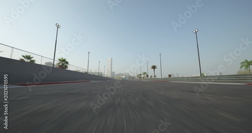 Three racing cars race toward the finish line, battling for first place. The camera pans toward them.
