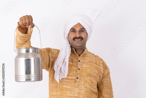 Fotografie Portrait of smiling young man wearing kurta pajama with white turban holding ste
