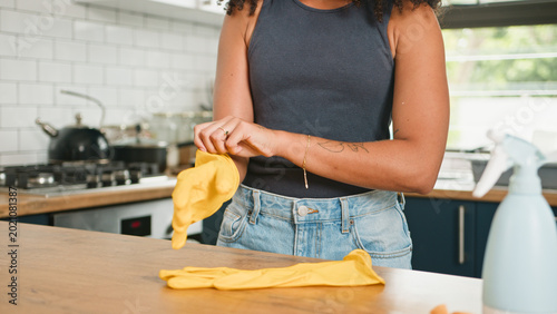 Cuadro en lienzo Woman Putting On Yellow Rubber Gloves In Modern Kitchen Preparing To Clean Count