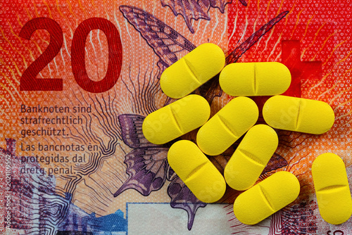 A twenty-franc Swiss banknote is shown with several identical medical pills lying on it