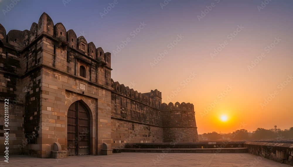 Fototapeta premium Historical architecture of Shaniwar Wada in Pune at sunset, featuring the majestic stone fort walls and wooden gate for Indian heritage and history concept