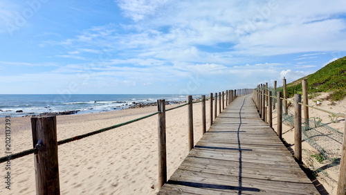 Wooden Boardwalk Leading Along the Sandy Coastline of Miramar Beach in Portugal