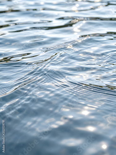 Close-up water surface texture with sunlight reflection and ripples