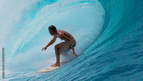 Photography CLOSE UP: Large tube wave curls behind fearless sportsman surfing in Tahiti