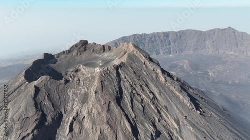 Aerial drone shot of Pico do Fogo volcano summit and its main crater in Cape Verde. Cinematic view of the rugged volcanic peak and caldera landscape in Chã das Caldeiras, Fogo Island