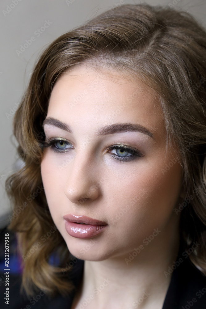 Naklejka premium Beauty salon and makeup. Women's hair salon. A young woman admires her new stylish hairstyle and makeup - vertical video.