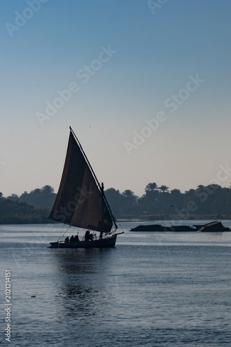 Obraz na plátně Traditional wooden sailboat felucca on a calm river at dusk