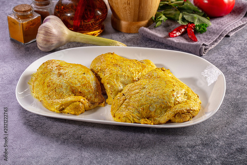 Cuadro en lienzo Raw chicken thighs marinated in yellow curry spice with fresh herbs and vegetabl