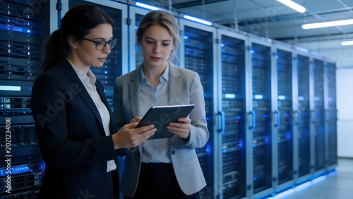 Two women in server room with tablet