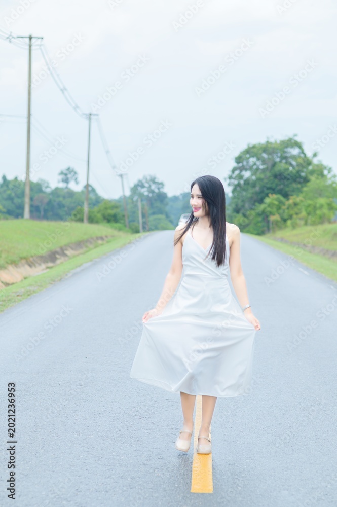 Fototapeta premium Elegant Woman Walking on Empty Road in Khao Yai, Thailand