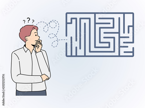 Thoughtful Businessman Looking at a Complex Maze and Trying to Find Solutions to a Business Problem