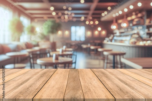 Empty wooden table top with blurred coffee shop and bokeh background for product display.