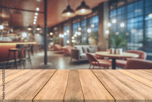 Empty wooden table top with blurred coffee shop and bokeh background for product display.