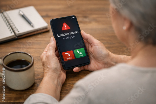 Older Woman at Risk as Suspicious Call Alert Appears on Mobile Device