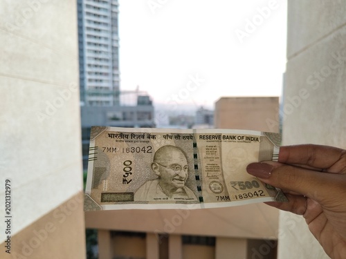 Bild auf Leinwand Indian 500 Rupee Banknote Held Against Urban Balcony View