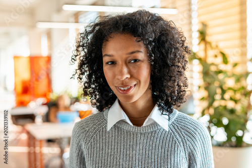 Obraz na płótnie Confident young woman smiling in modern office workplace