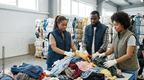 Volunteers sorting used clothes for recycling and donation in a warehouse.
