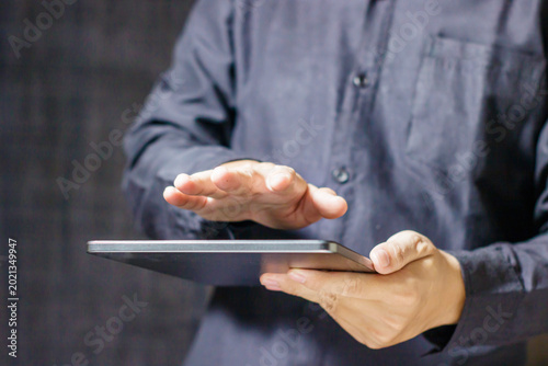 Tableau sur toile Man using digital tablet with hand hovering over screen