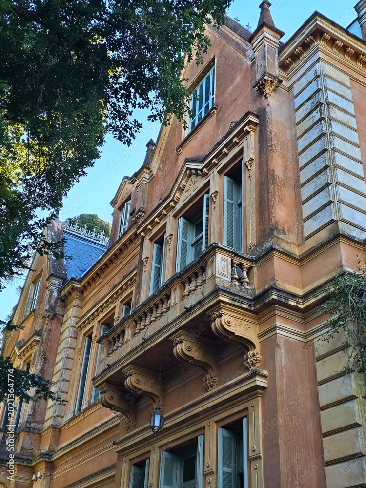 Obraz premium Elegant historic building facade with trees and blue sky
