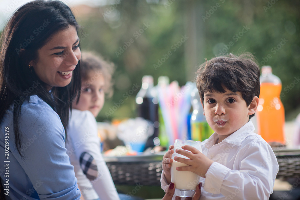 Fototapeta premium Modern Middle Eastern family enjoying Ramadan iftar dinner together with children and milk