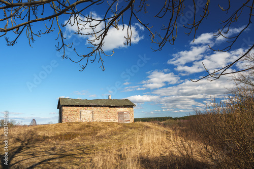 Old Rustic Stone Building on a Hill Under Vibrant Blue Sky