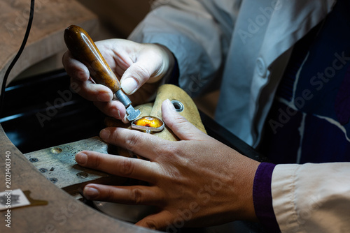 Tableau sur toile A female stonesetter fixing an amber stone into a silver ring.