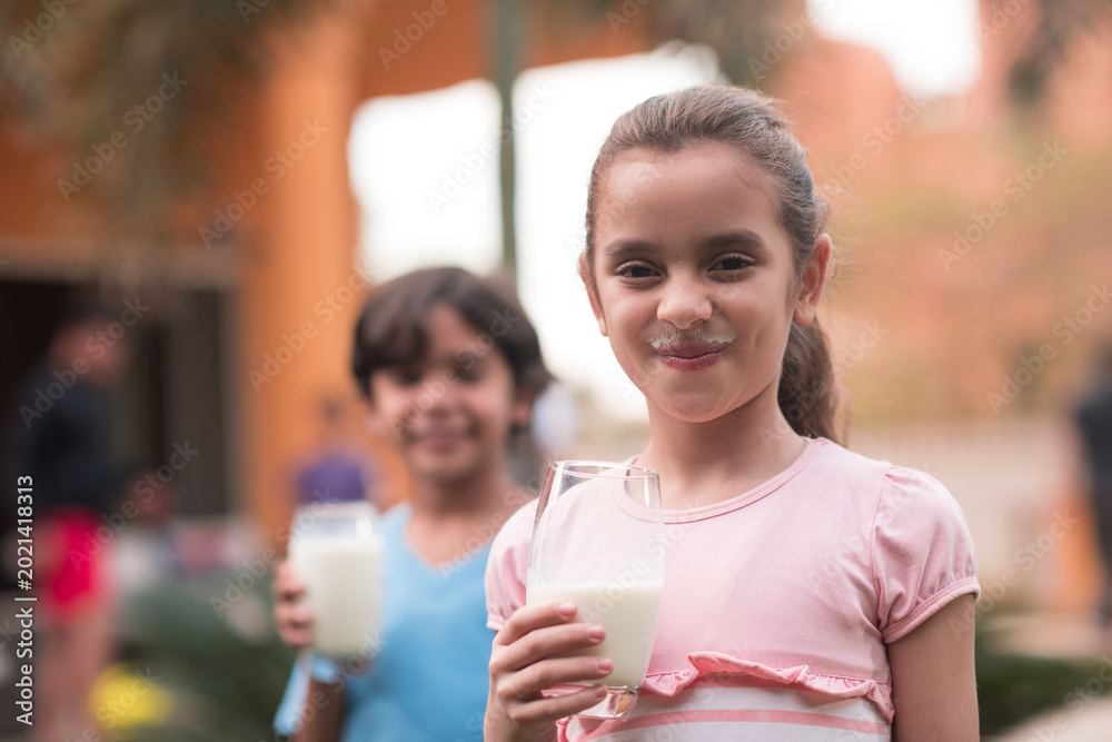 Fototapeta premium Children enjoying milk together during Eid Ramadan iftar at a modern Middle Eastern family gathering