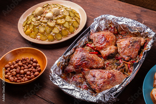 Chicken pieces baked in spices on foil with a golden crust in a baking dish