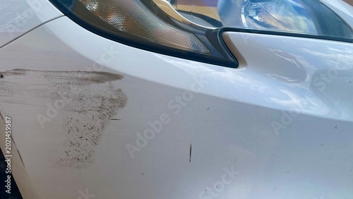 Foto Vehicle Dent: A close-up view of a car reveals damage, highlighting scratches and dents, suggesting an accident or collision