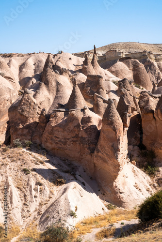 vertical photograph of fairy chimneys on a hill in Cappadocia during an August day in the Devrent Valley in Cappadocia during an August day