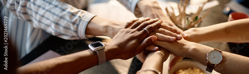 Fényképezés Website header shot of diverse business team joining hands in workplace, symbolizing teamwork, trust, collaboration, close up view