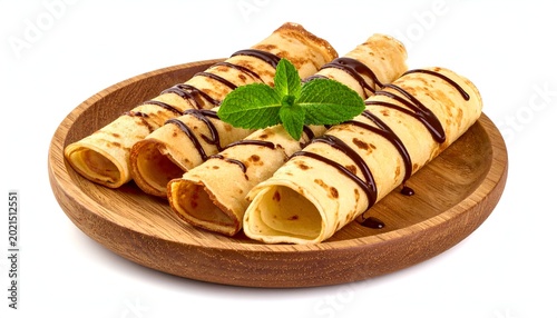 Rolled pancakes, chocolate drizzle & mint on a wooden plate. Studio shot